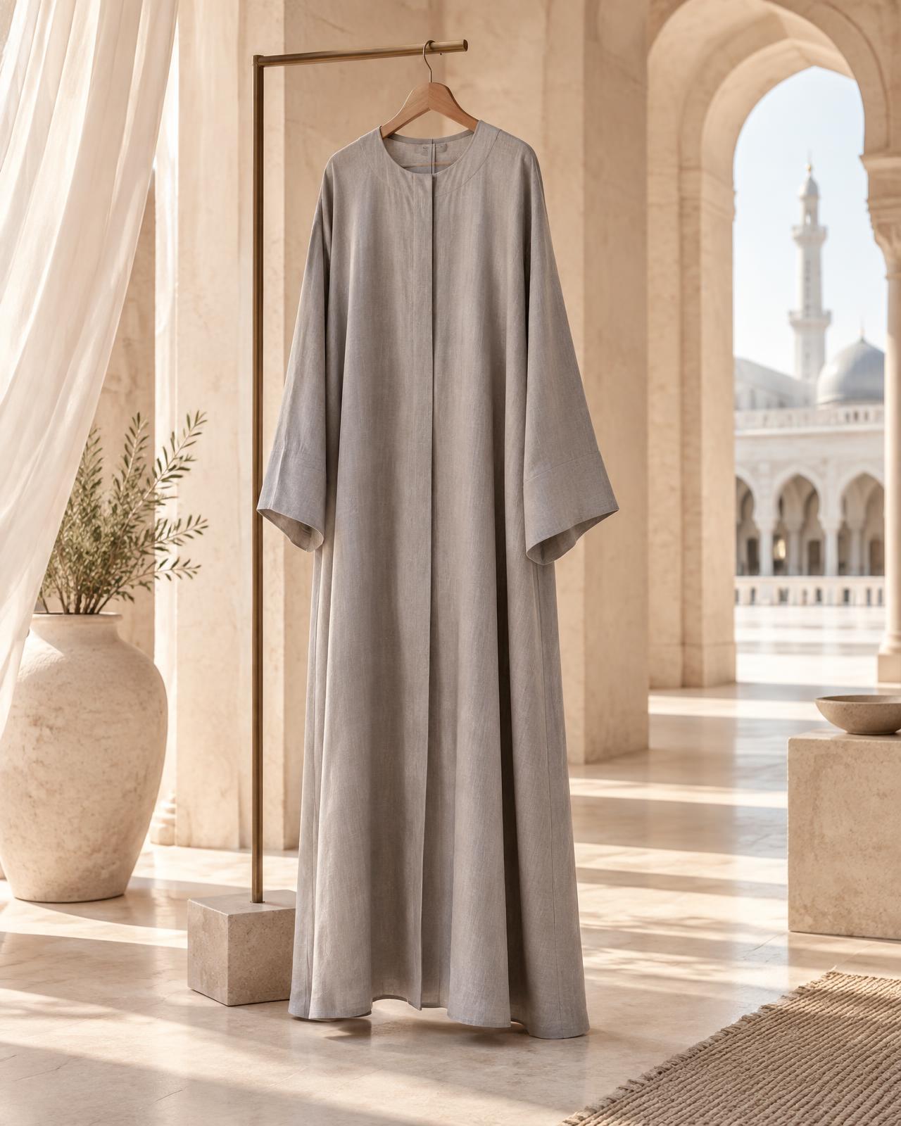 Stone-gray linen abaya displayed in a serene arched interior